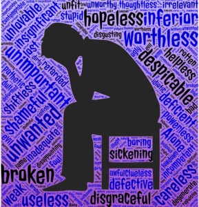 silhouette of man hunched in chair, with negative words like hopeless, inferiort, and worthless in a word cloud around him
