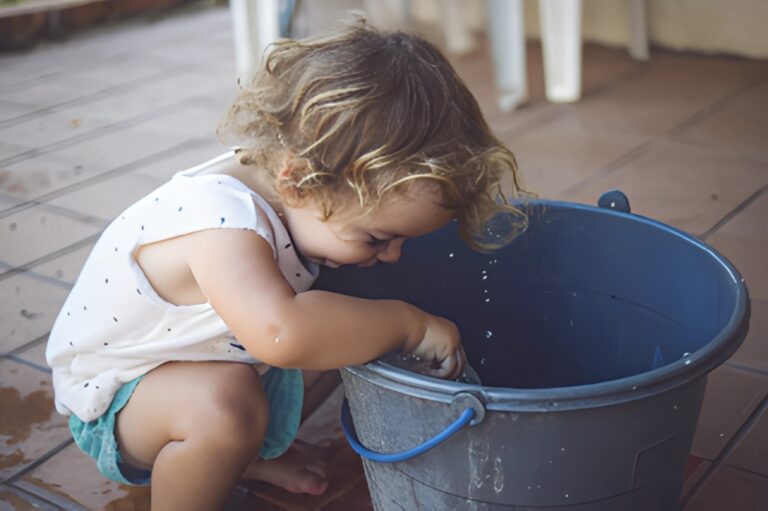 child with hand in bucket