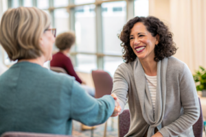 woman welcoming a newcomer at a meeting