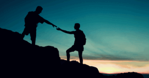 reaching out to help another man up the mountain