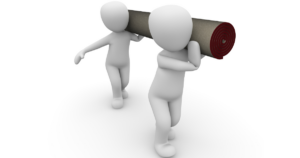 two men carry a heavy object together